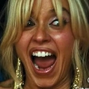 Woman with blonde hair making a wide-eyed, open-mouthed expression of intense shock or insanity.