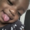 Toddler sticking their tongue out with a mischievous and playful expression.