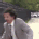 Eric Andre in a suit frantically banging on a fence.