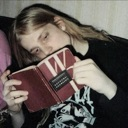 Pelle Ohlin holding a book while looking down with a somber expression.