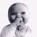 Baby with a knowing smirk and hand near mouth.