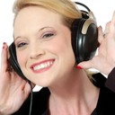 Woman smiling while wearing large black headphones.