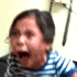 Young girl with a striped shirt screaming with her mouth wide open.