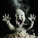 A dusty baby emerges from a pile of debris with its mouth wide open in a panicked scream.