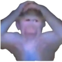 Monkey holding its head with a panicked and distorted facial expression.