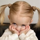 A young blonde girl with pigtails resting her chin on her hands with a suspicious and judgmental expression.