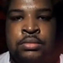A man with a serious, unimpressed expression staring directly at the camera.