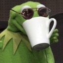 Kermit the Frog wearing sunglasses and holding a white mug while sipping tea.