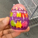 A purple plastic egg labeled Party with My Bunny held in a hand.