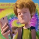 Shaggy Rogers looking down at his smartphone with a confused and skeptical facial expression.