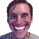 Man with a distorted, extremely wide grin looking directly at the camera.