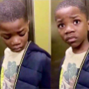 Young boy looking down then looking up with a skeptical and annoyed expression.