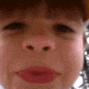 A child making a spitting gesture with their lips close to the camera lens.